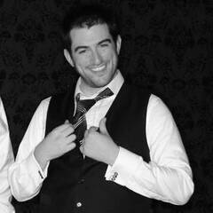 Twitter profile photograph of Allen Eckhouse wearing a waistcoat and tie